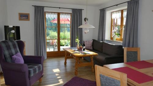 ein Wohnzimmer mit einem Sofa und einem Tisch in der Unterkunft Albingers Landhaus in Balderschwang