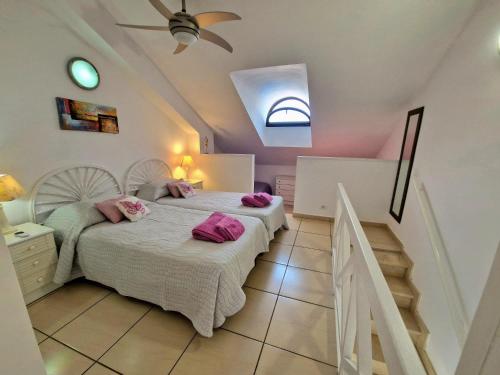 a bedroom with a bed with pink pillows on it at Parque Santiago 1 F-348 by TENERIFE DREAM PROPERTIES in Playa de las Americas
