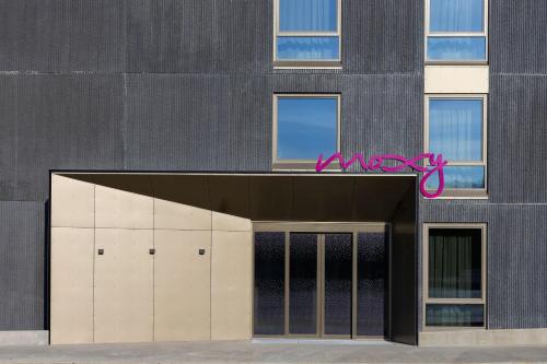 a building with a garage with a pink sign above it at Moxy Tromso in Tromsø