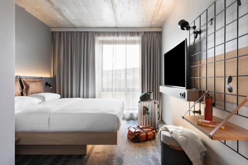a hotel room with a bed and a television at Moxy Tromso in Tromsø