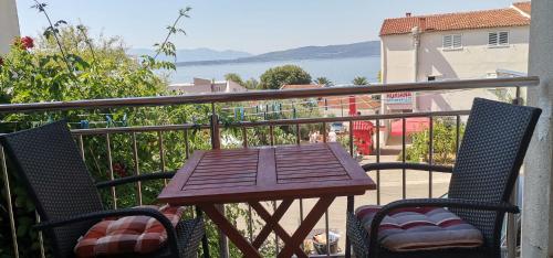 a wooden table and two chairs on a balcony at Apartmani ANDRIJA in Živogošće