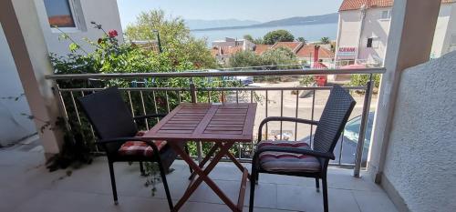 a wooden table and two chairs on a balcony at Apartmani ANDRIJA in Živogošće