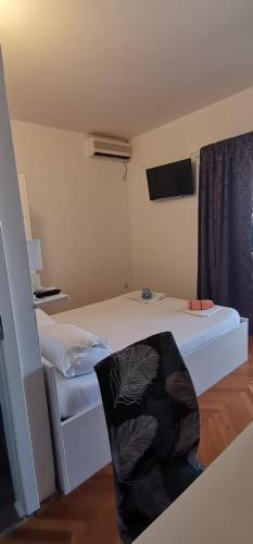 a small bedroom with a bed and a television at Apartmani ANDRIJA in Živogošće