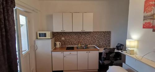 a kitchen with a white refrigerator and a sink at Apartmani ANDRIJA in Živogošće