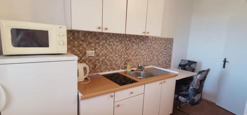 a small kitchen with a sink and a microwave at Apartmani ANDRIJA in Živogošće