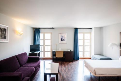 a living room with a couch and a table at Palacio de los Blasones Suites in Burgos