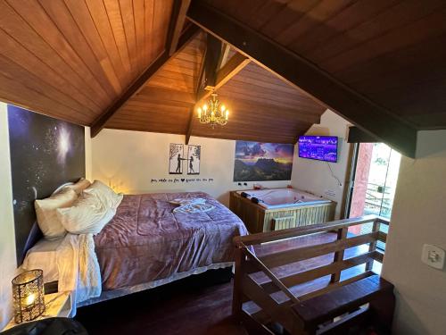 1 dormitorio con 1 cama y TV en una habitación en Recanto Lira I en Monte Verde