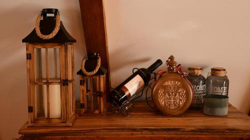 a wooden shelf with bottles and a candle and a lantern at Milošev Konak in Malo Središte