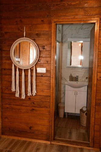 baño con pared de madera con espejo y lavabo en Milošev Konak, en Malo Središte