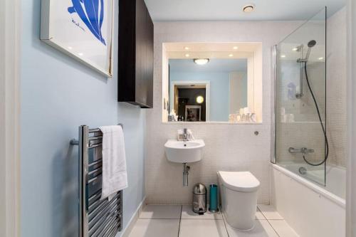 a bathroom with a sink and a toilet and a shower at GuestReady - Stylish Haven in Tower Hamlets in London