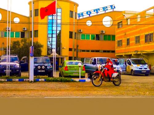 una persona en motocicleta frente a un edificio en Hotel Complex Europe, en Guercif