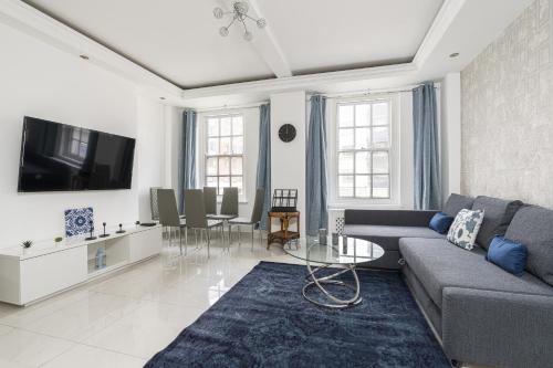 - un salon avec un canapé et une télévision dans l'établissement Marble Arch Apartments, à Londres
