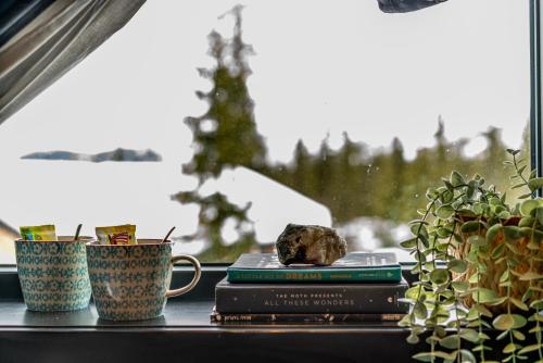 a window sill with two cups and books and a rock at Private Room in Beautiful Mountain Home w/ Sauna in Beitostøl