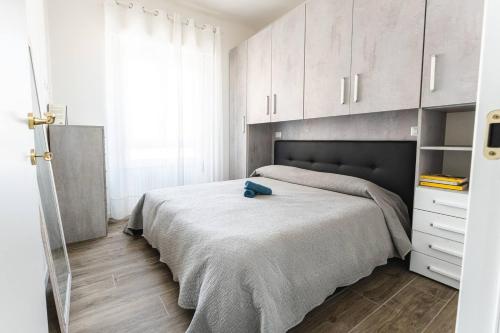 um quarto com uma cama grande e armários brancos em SeRa Suite em Cagliari