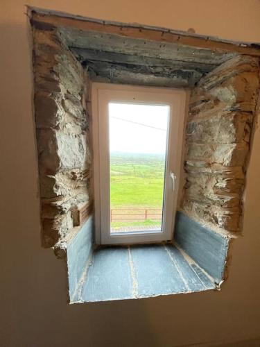 a window in a room with a stone wall at Glenogue Farm in Gorey