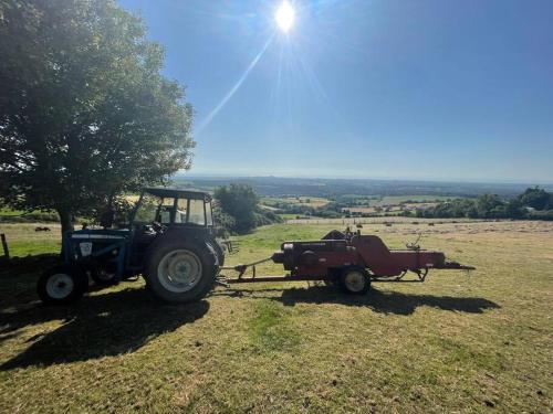 two tractors are parked in a field with the sun at Glenogue Farm in Gorey