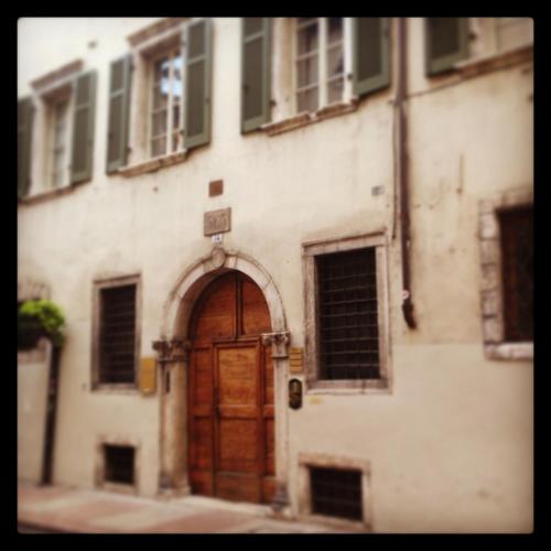 an old building with a wooden door on a street at Al Cavour 34 in Trento