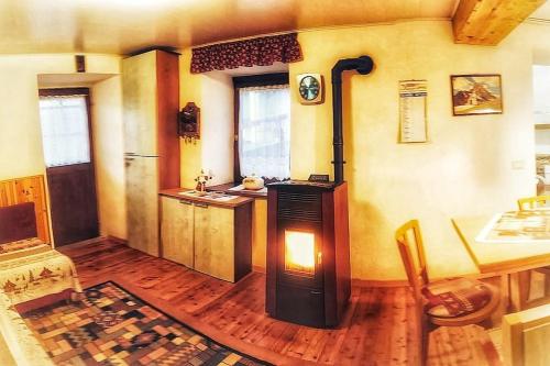 a kitchen with a woodburning stove in a room at Cozy Alpine House di Svaizer in San Martino di Castrozza