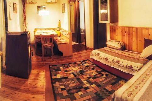 a bedroom with a bed and a table and a rug at Cozy Alpine House di Svaizer in San Martino di Castrozza