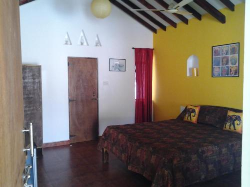 1 dormitorio con 1 cama y puerta de madera en Starco, en Anjuna