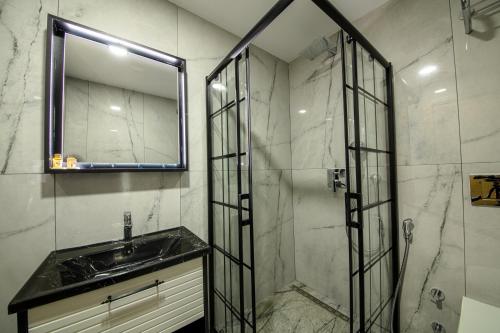 a bathroom with a sink and a shower with a mirror at Air Barbaros Hotel Trabzon in Trabzon
