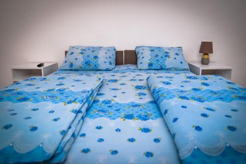 a bedroom with a blue bed with blue sheets and pillows at Marko Polo Apartment in Sarajevo