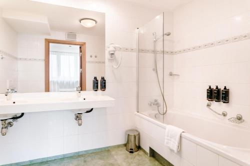 a white bathroom with a sink and a shower at Hotel Mercure Toruń Centrum in Toruń