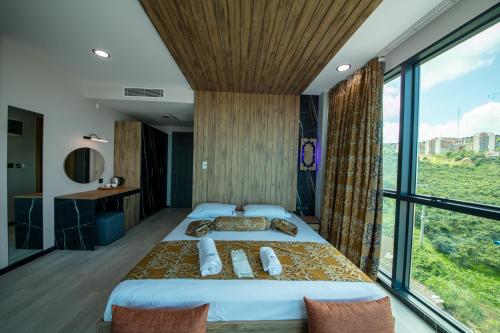 a bedroom with a large bed and a large window at Air Barbaros Hotel Trabzon in Trabzon