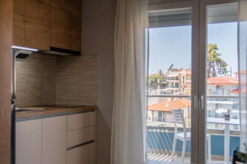 a kitchen with a balcony with a view of a building at Unique Aura Luxury Studios in Neos Marmaras