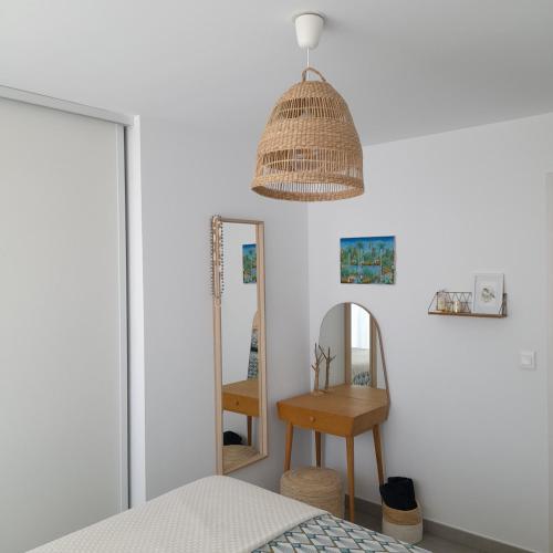 une chambre avec un lit et un miroir dans l'établissement Superbe appartement en résidence proche du centre, à Biarritz
