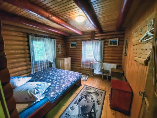 1 dormitorio con 1 cama en una cabaña de madera en Private House Затишок, en Zhdeniievo