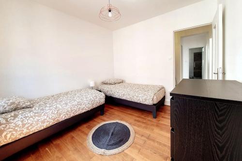 Cette chambre comprend 2 lits et un miroir. dans l'établissement CHIC - Proche Hypercentre - Rénové - Lumineux, à Strasbourg