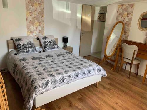 une chambre avec un lit, une table et un miroir dans l'établissement Logement indépendant -1 chambre -3 lits - 4km du circuit, à Ruaudin