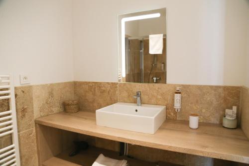 a bathroom with a white sink and a mirror at Domaine de La Font des Pères - Teritoria in Le Beausset