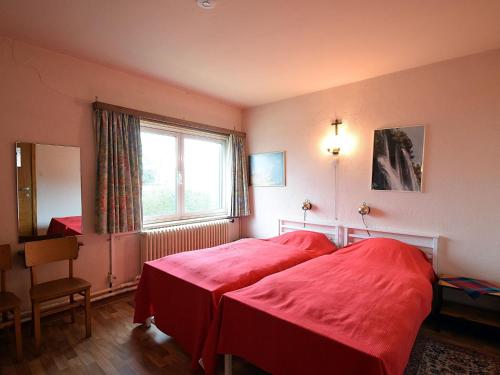 1 Schlafzimmer mit 2 roten Betten und einem Fenster in der Unterkunft Cotanou V villa in De Haan with garden in De Haan