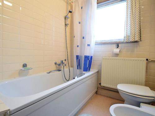 ein Badezimmer mit einer Badewanne, einem WC und einem Waschbecken in der Unterkunft Cotanou V villa in De Haan with garden in De Haan