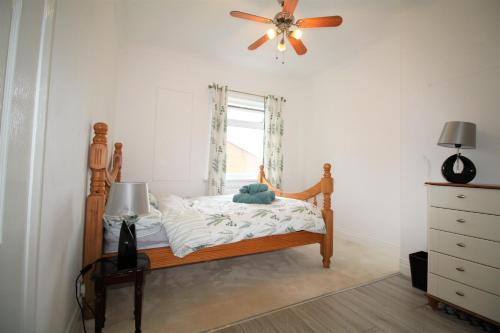 um quarto com uma cama e uma ventoinha de tecto em Whitley Bay - Sleeps 6 - Refurbished Throughout - Fast Wifi - Dogs Welcome em Whitley Bay
