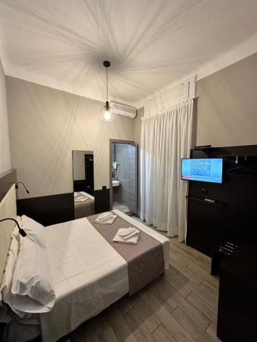 a hotel room with a bed and a television at Hotel Bogart Milano in Milan