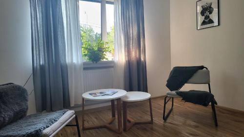 a living room with a chair and a table and a window at Villa Saulkrasti Balta Kapa White Dunes in Saulkrasti