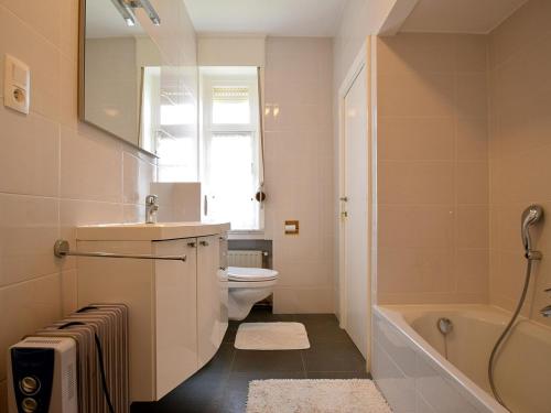 y baño con aseo, lavabo y bañera. en Beautiful Normandy villa in an exclusive location, en De Haan