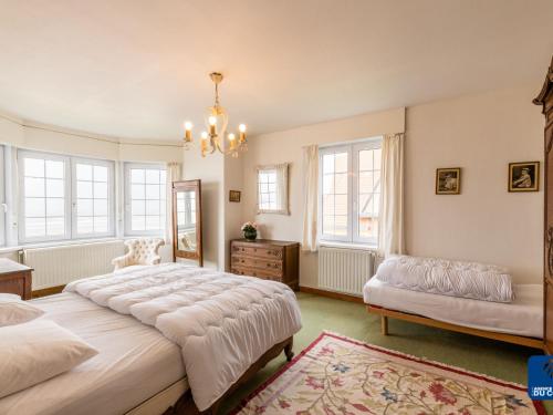 1 dormitorio con 2 camas y lámpara de araña en Beautiful Normandy villa in an exclusive location, en De Haan