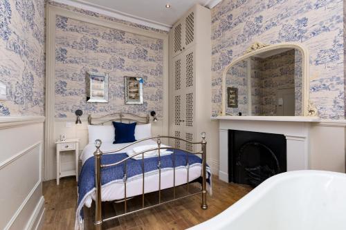 a bedroom with a bed with blue and white wallpaper at Bower House in London