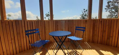 two blue chairs and a table on a porch at LES CABANES DE LUTINA in Poggio-Marinaccio