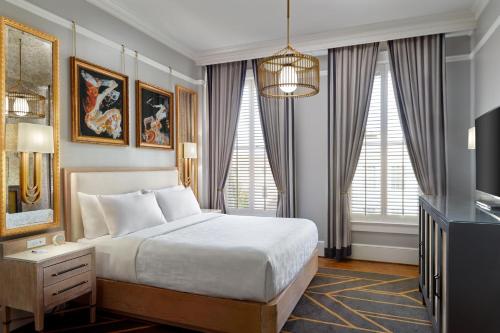 a hotel room with a bed and a television at The Tremont House, Galveston, a Tribute Portfolio Hotel in Galveston