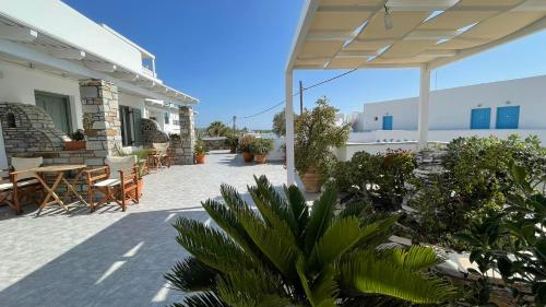 un patio con mesa, sillas y plantas en Summer Times Studios, en Naxos Chora