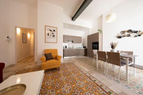 a kitchen and living room with a dining table and chairs at Traditional 2 bedroom house with yard SSCH1 in St Julian's