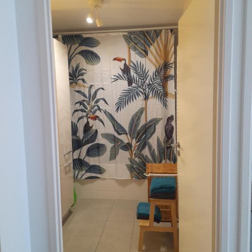 un couloir avec une fresque de palmiers et d'oiseaux dans l'établissement Superbe appartement en résidence proche du centre, à Biarritz