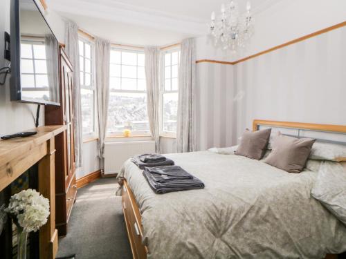 a bedroom with a bed and a tv and windows at 44 Elm Road in Plymouth