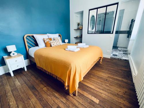 a bedroom with a bed with an orange blanket at "Le Général" Appartement prestige proche gare, haut-de-gamme, avec billard et parking privé, by PRIMO C0NCIERGERIE in Nevers