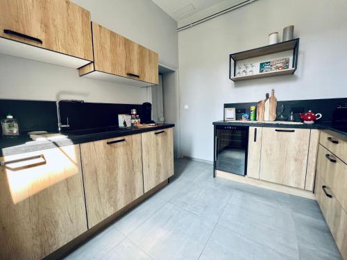 a kitchen with wooden cabinets and a counter top at "Le Général" Appartement prestige proche gare, haut-de-gamme, avec billard et parking privé, by PRIMO C0NCIERGERIE in Nevers